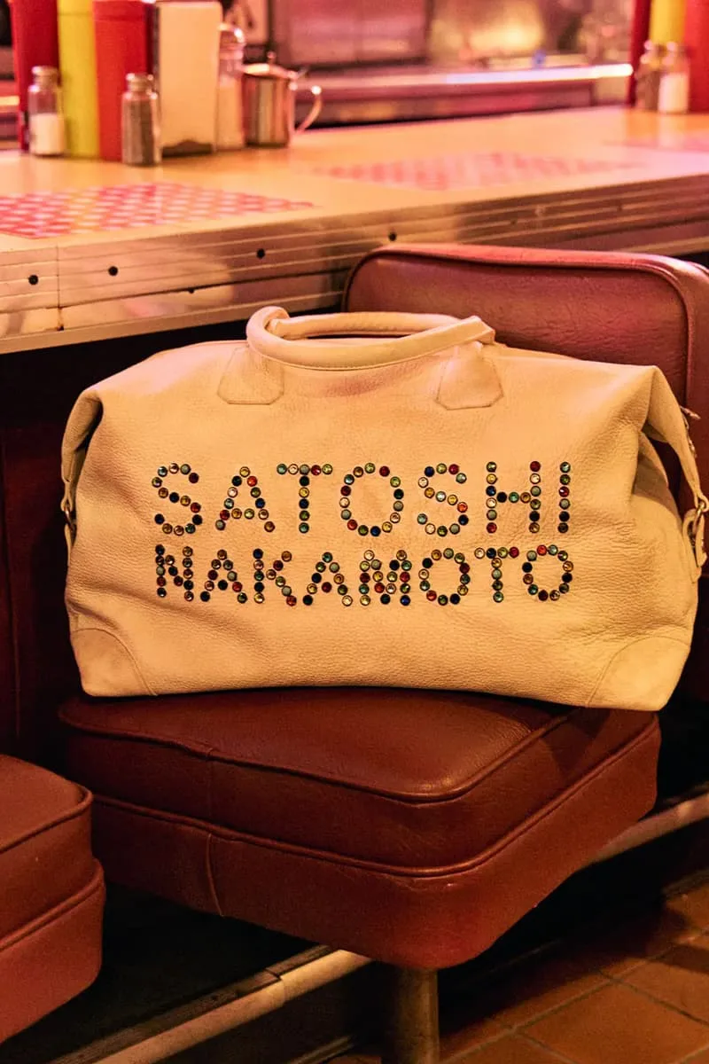 Sac blanc avec 'Satoshi Nakamoto' sur une chaise dans un café rétro