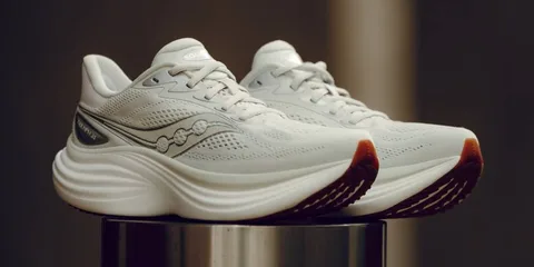 Chaussures de sport blanches avec semelle épaisse exposées sur une surface métallique.