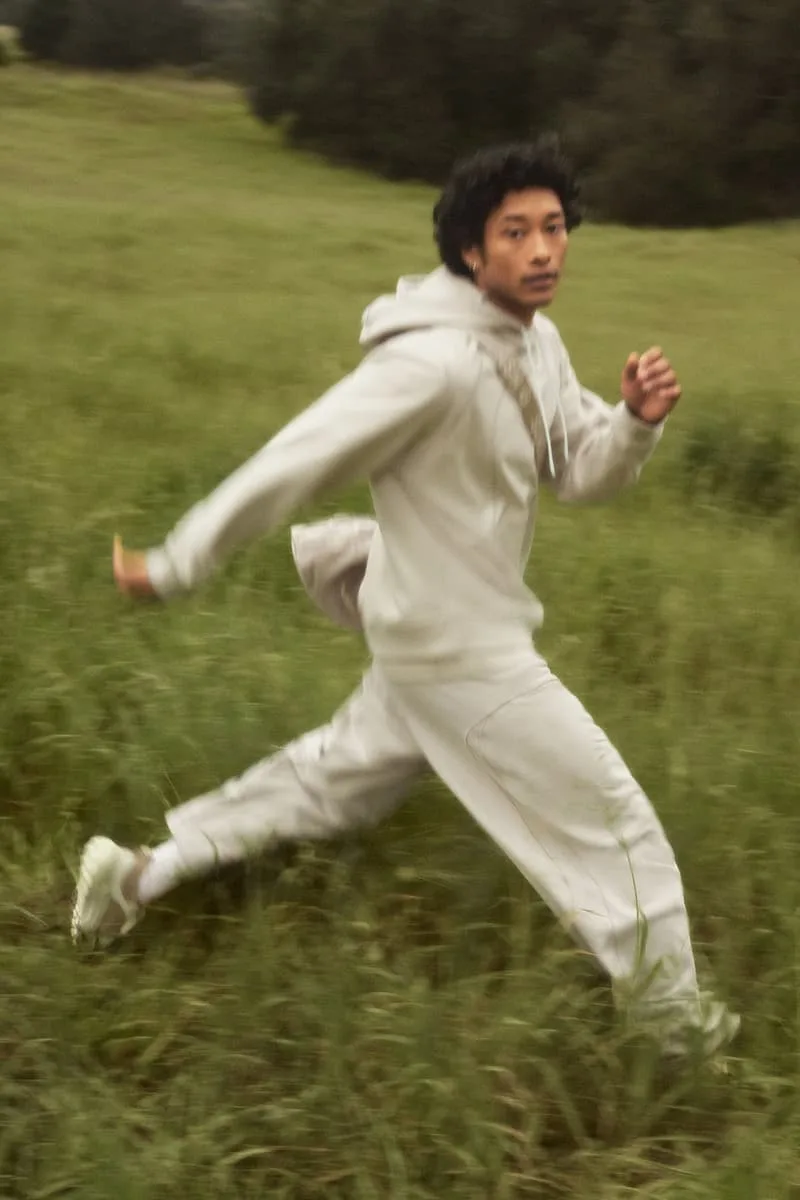 Homme courant dans un champ en tenue décontractée beige.