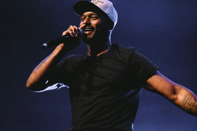 Chanteur sur scène avec casquette et micro