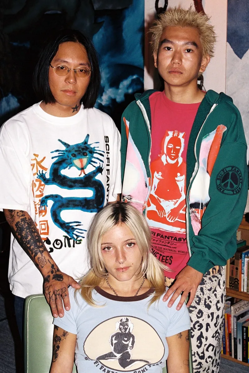 Trois personnes posant ensemble avec des vêtements graphiques.