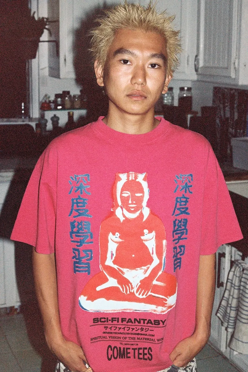 Personne avec cheveux blonds, portant un t-shirt rouge imprimé.