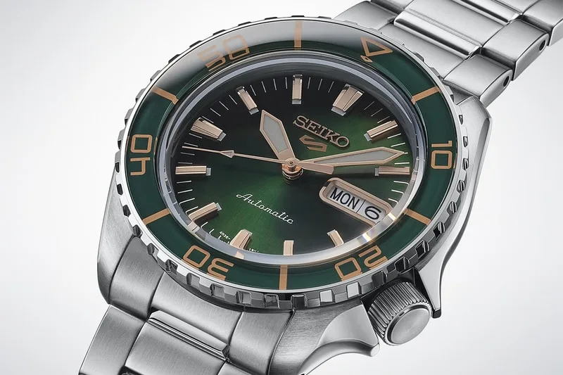 Montre Seiko automatique en métal avec cadran vert, index dorés, bracelet argenté.