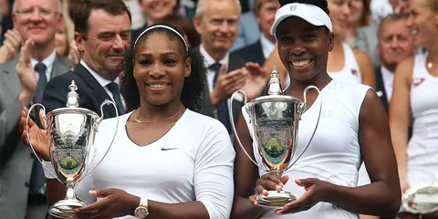 Deux joueuses de tennis avec des trophées à Wimbledon.