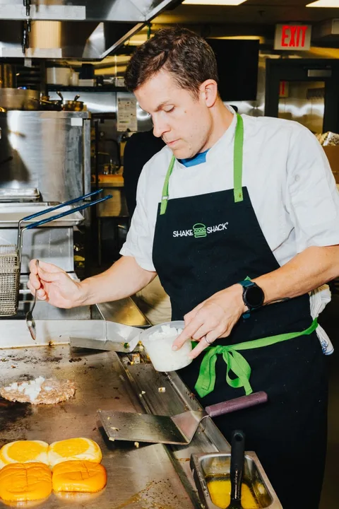 Chef prépare des hamburgers dans une cuisine de restaurant