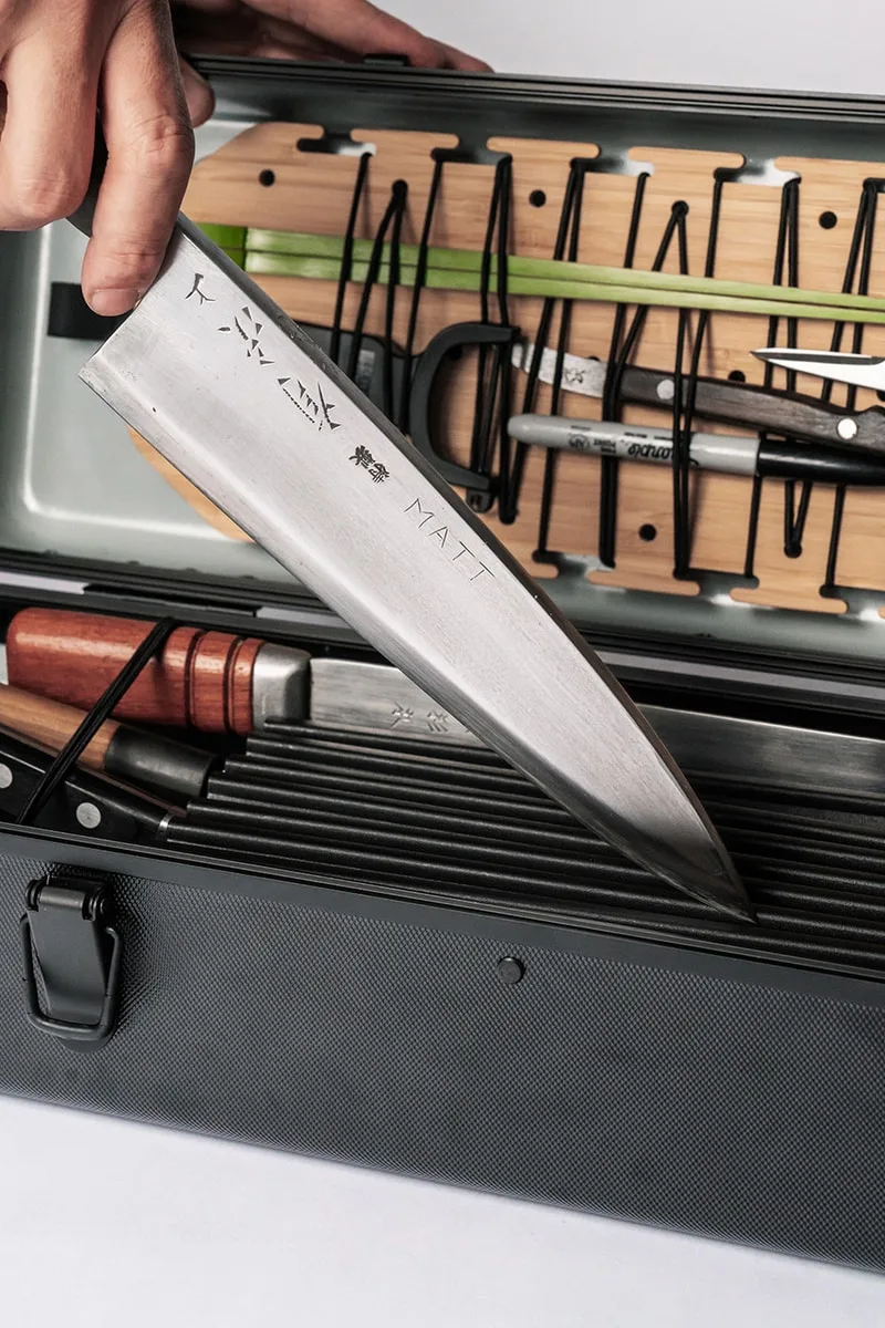 Couteau gravé et outils dans une boîte métallique.