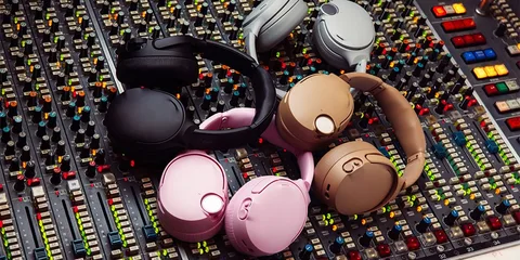 Casques colorés sur une console de mixage, ambiance studio.