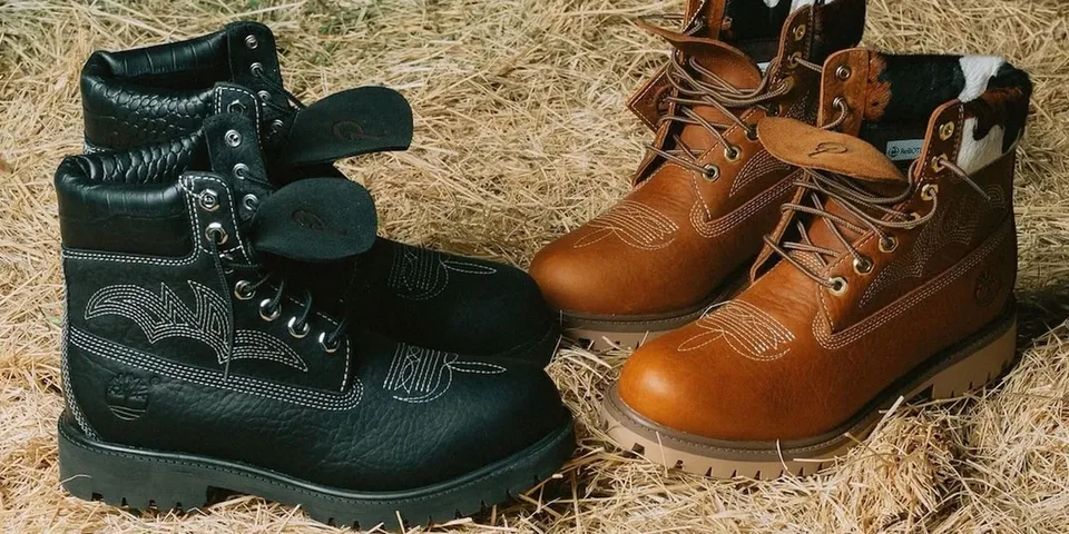 Deux paires de bottes sur du foin, noires et marron, avec des détails en cuir.