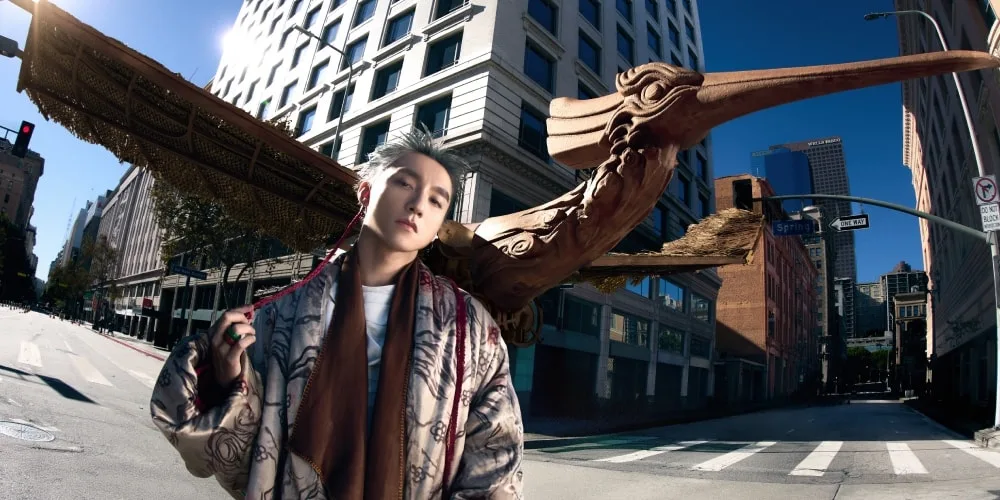 Homme avec un oiseau géant en arrière-plan dans une rue de ville.
