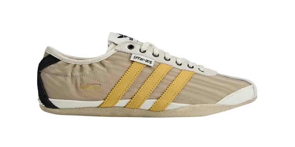 Chaussure beige et jaune avec bande Adidas et texte 'Tokyo'.