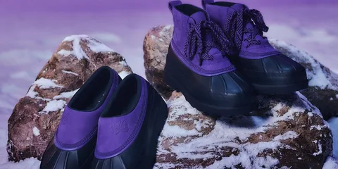 Chaussures violettes et noires sur des rochers enneigés.