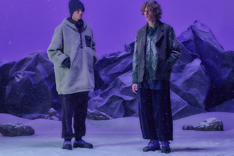 Deux personnes en vêtements d'hiver dans un paysage enneigé et violet.