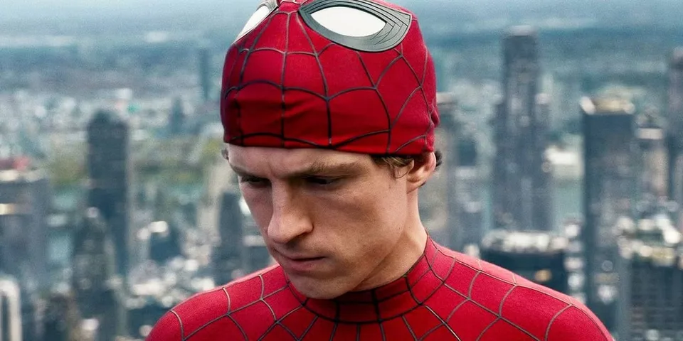 Personnage en costume rouge de super-héros devant une ville floue.