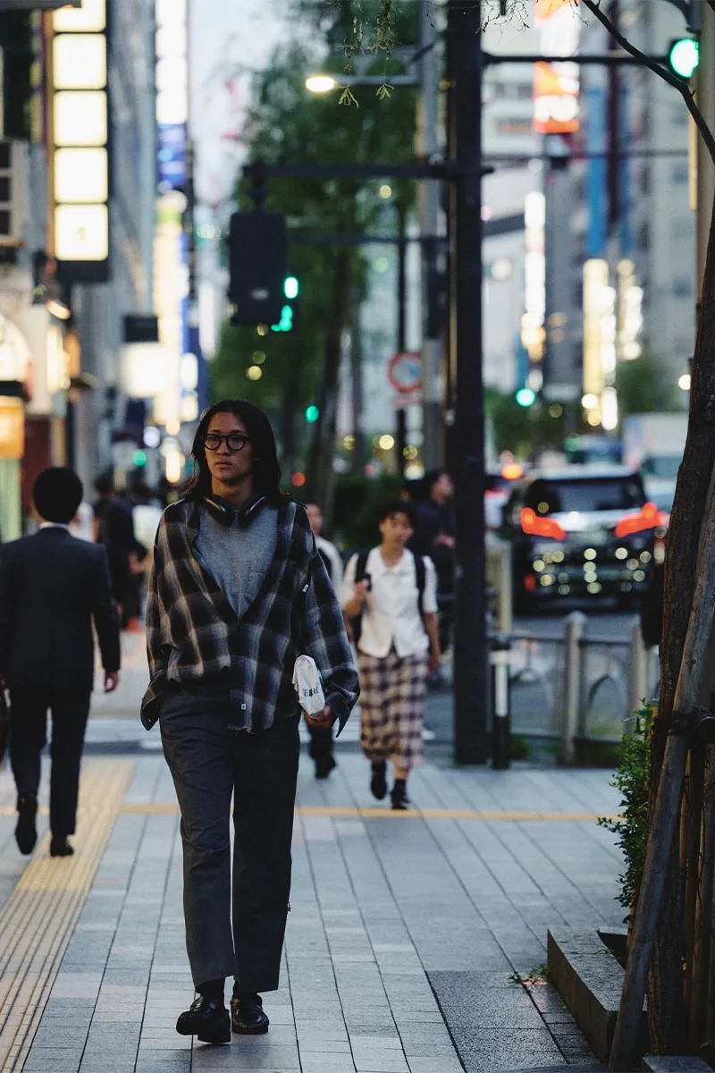 Personne marchant dans une rue animée le soir.