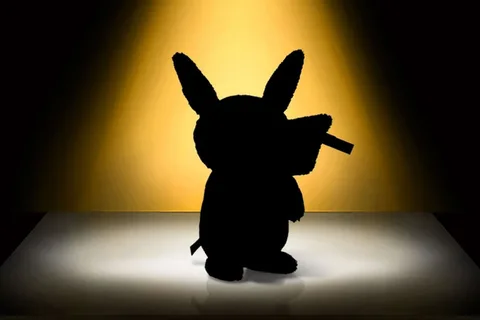 Silhouette d'une peluche avec oreilles pointues sur fond jaune lumineux.