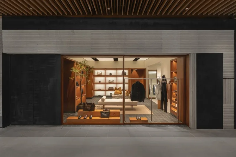 Boutique moderne avec étagères, vêtements et accessoires en vitrine.