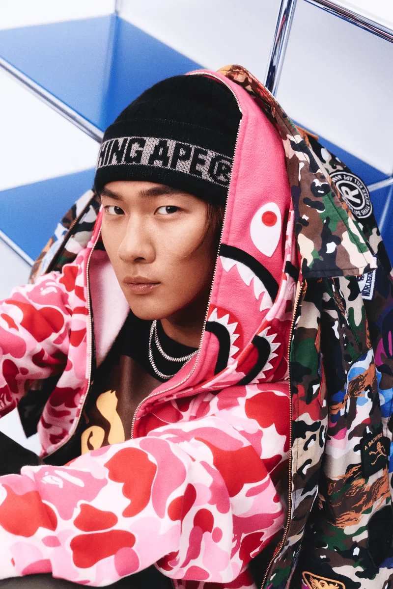Homme portant des vêtements colorés avec motifs camouflage et design moderne.