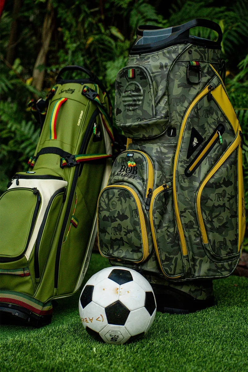 Sacs de golf camouflage et ballon de foot sur gazon.