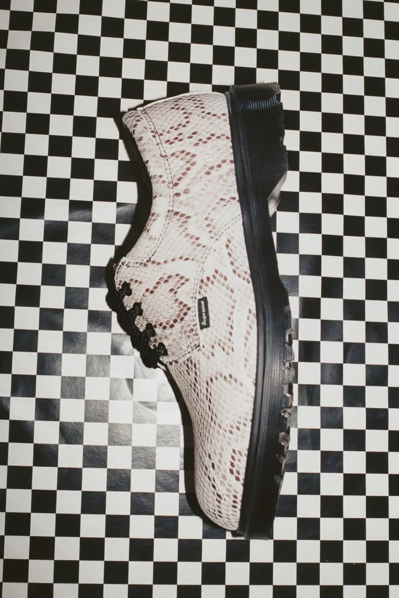 Chaussure à motifs serpent sur fond à damier noir et blanc.