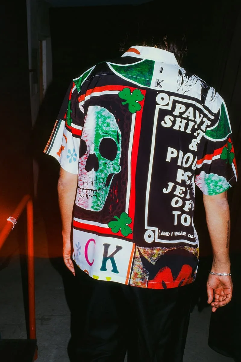Homme portant une chemise colorée avec des motifs graphiques et un crâne.