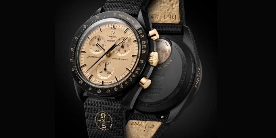 Montre Omega noire et dorée avec bracelet noir.
