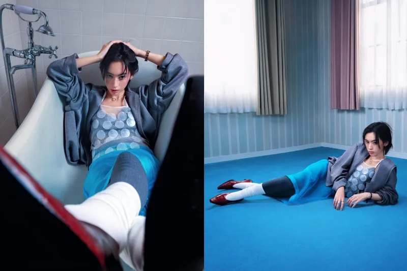 Femme posant dans une baignoire et sur un tapis bleu, tenue mode contemporaine.