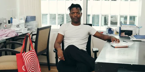 Un homme assis à un bureau dans un atelier de couture.