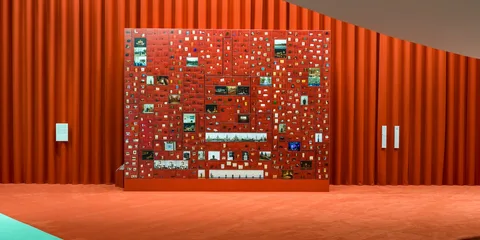 Mur rouge avec collection de photos carrées, intérieur artistique.