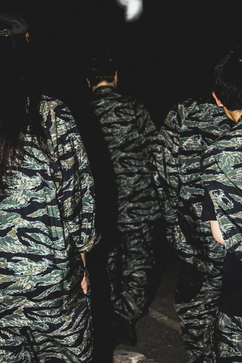 Personnes en uniforme camouflage de dos dans l'obscurité.