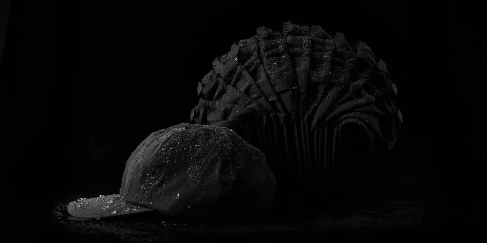 Un chapeau et un autre objet sombre sur fond noir.