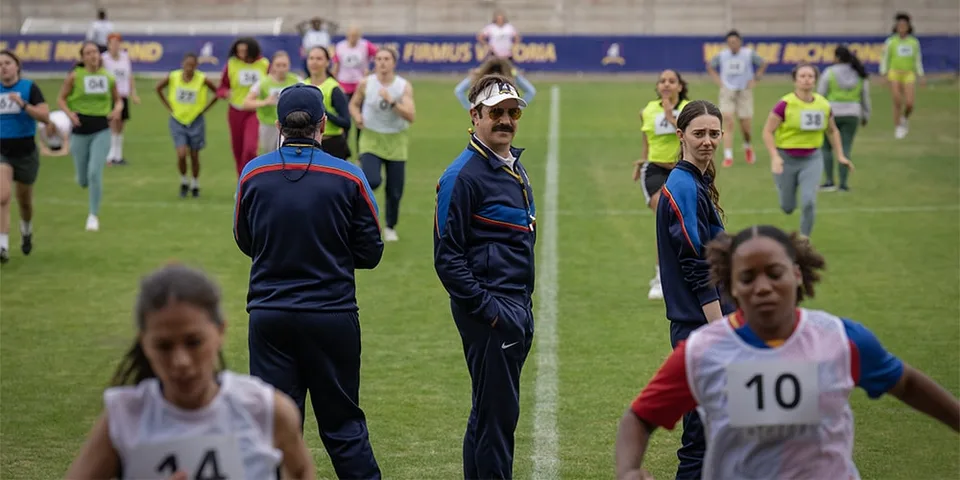 Personnes courant sur un terrain de sport, coachs au centre.