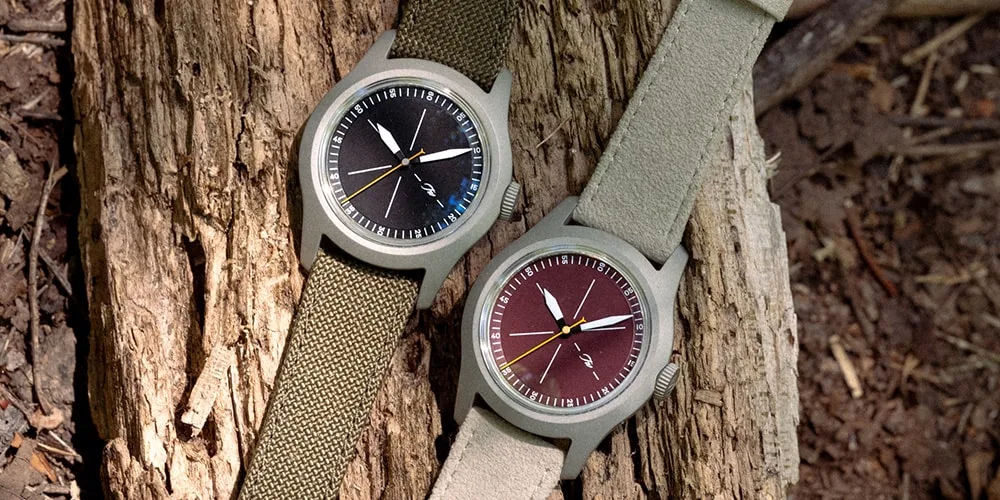 Deux montres avec bracelets en tissu sur un fond en bois.