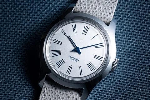 Montre élégante avec cadran argenté et chiffres romains.