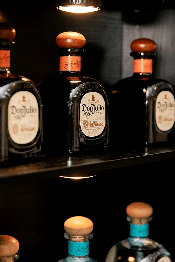 Bouteilles de tequila Don Julio dans un éclairage tamisé