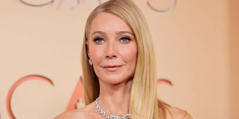 Gwyneth Paltrow pose sur un tapis rouge, vêtue d’une robe argentée.