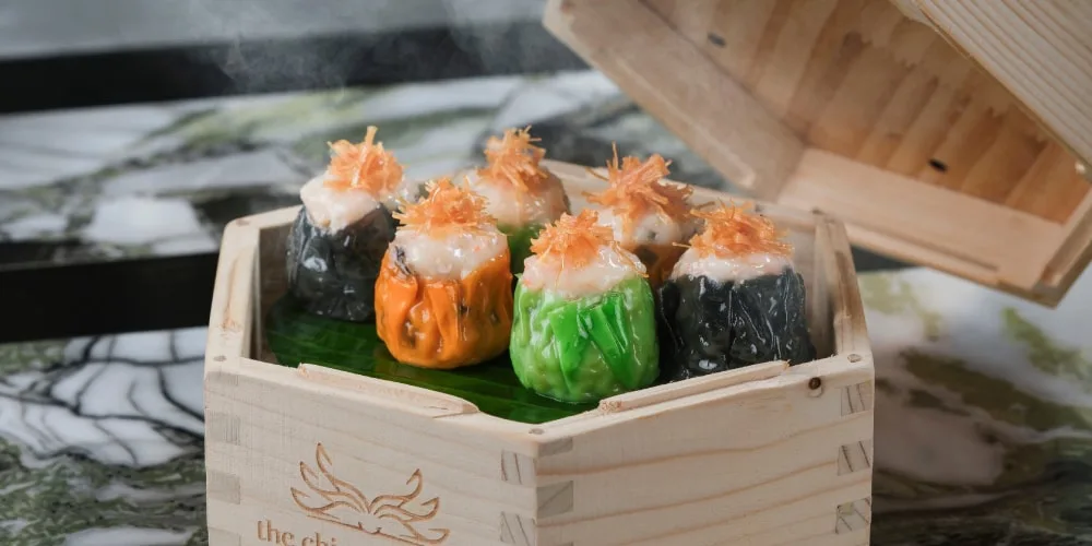 Assortiment de dim sum colorés dans une boîte en bois.