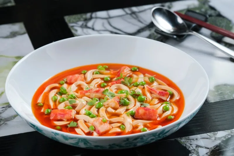 Soupe de nouilles épicée avec crevettes et pois verts.
