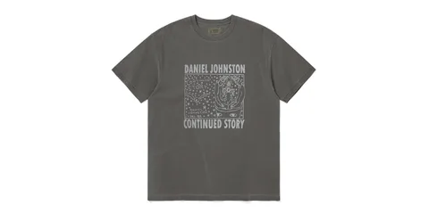 T-shirt gris avec dessin de Daniel Johnston, texte 'Continued Story' en blanc.