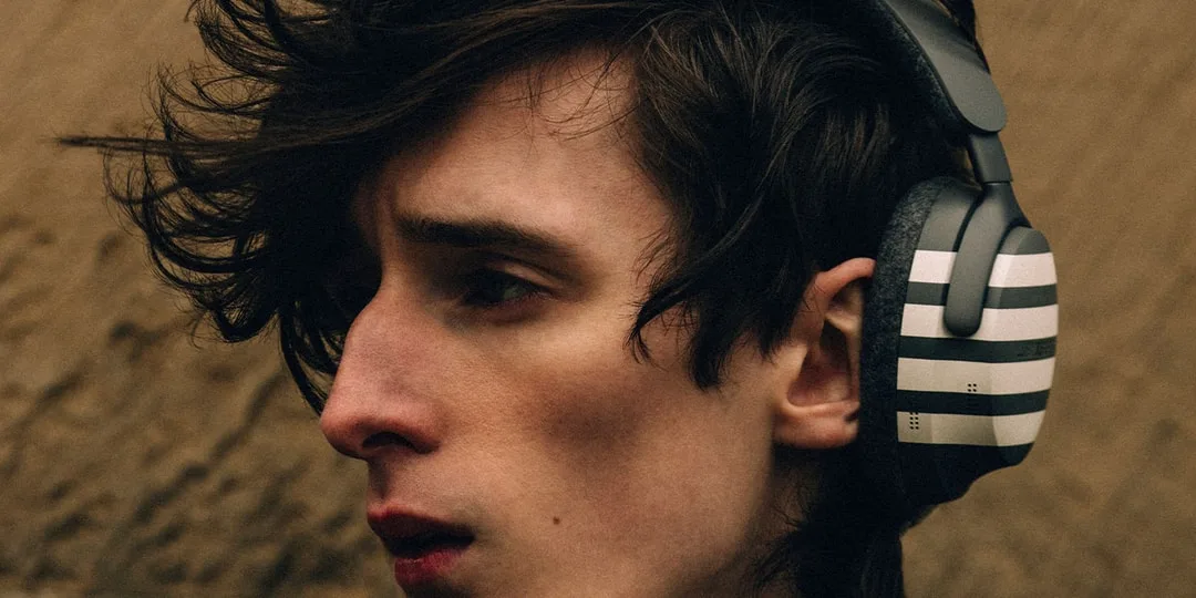 Homme portant un casque audio moderne avec un design rayé.
