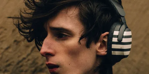 Homme portant un casque audio moderne avec un design rayé.