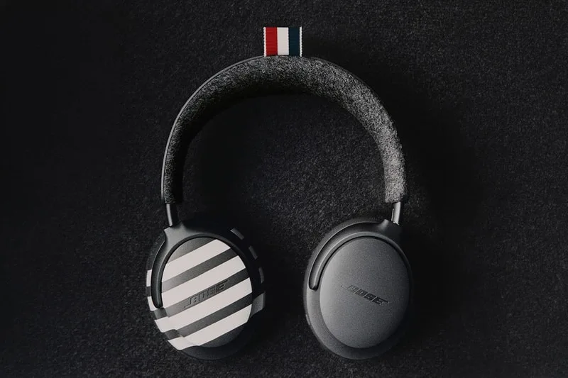 Casque audio noir avec logo rayé sur fond sombre.