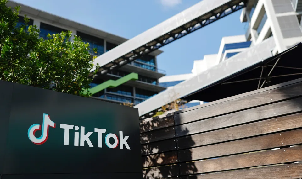 Logo TikTok sur un panneau devant un immeuble moderne.