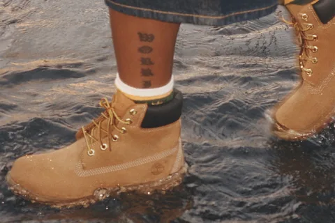 Bottes en cuir marron marchant dans l'eau.