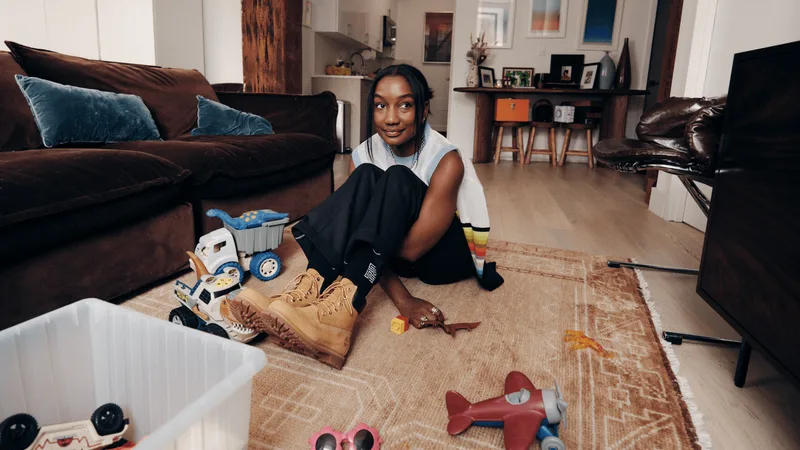 Personne assise avec des jouets dans un salon moderne.
