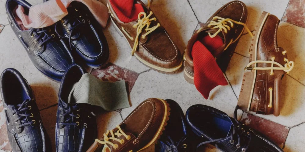 Chaussures bateau avec chaussettes colorées sur un sol en damier.
