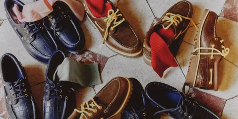 Chaussures bateau avec chaussettes colorées sur un sol en damier.