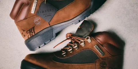 Chaussures marron Timberland sur sol beige.