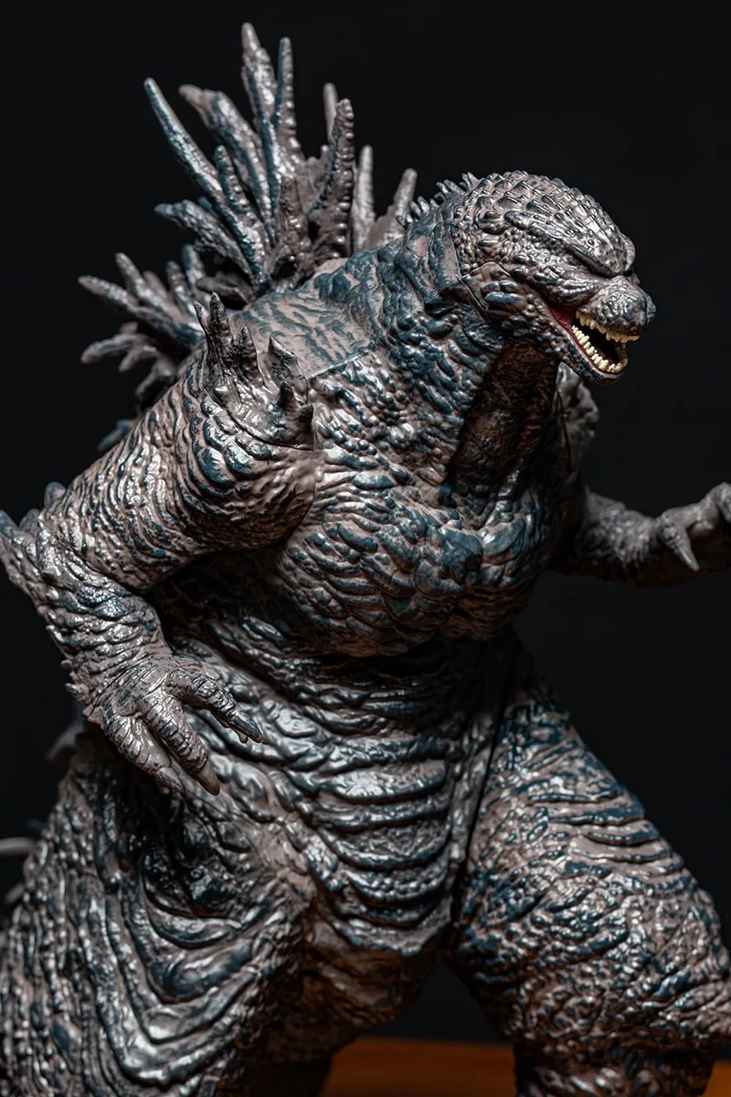 Figurine détaillée de Godzilla sur fond noir.