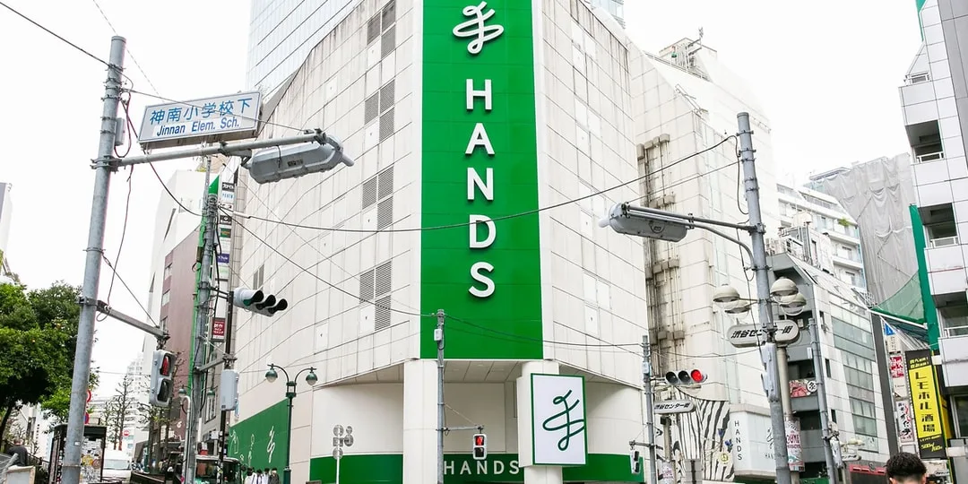 Magasin 'Hands' dans un bâtiment moderne avec panneaux verts.