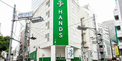 Magasin 'Hands' dans un bâtiment moderne avec panneaux verts.